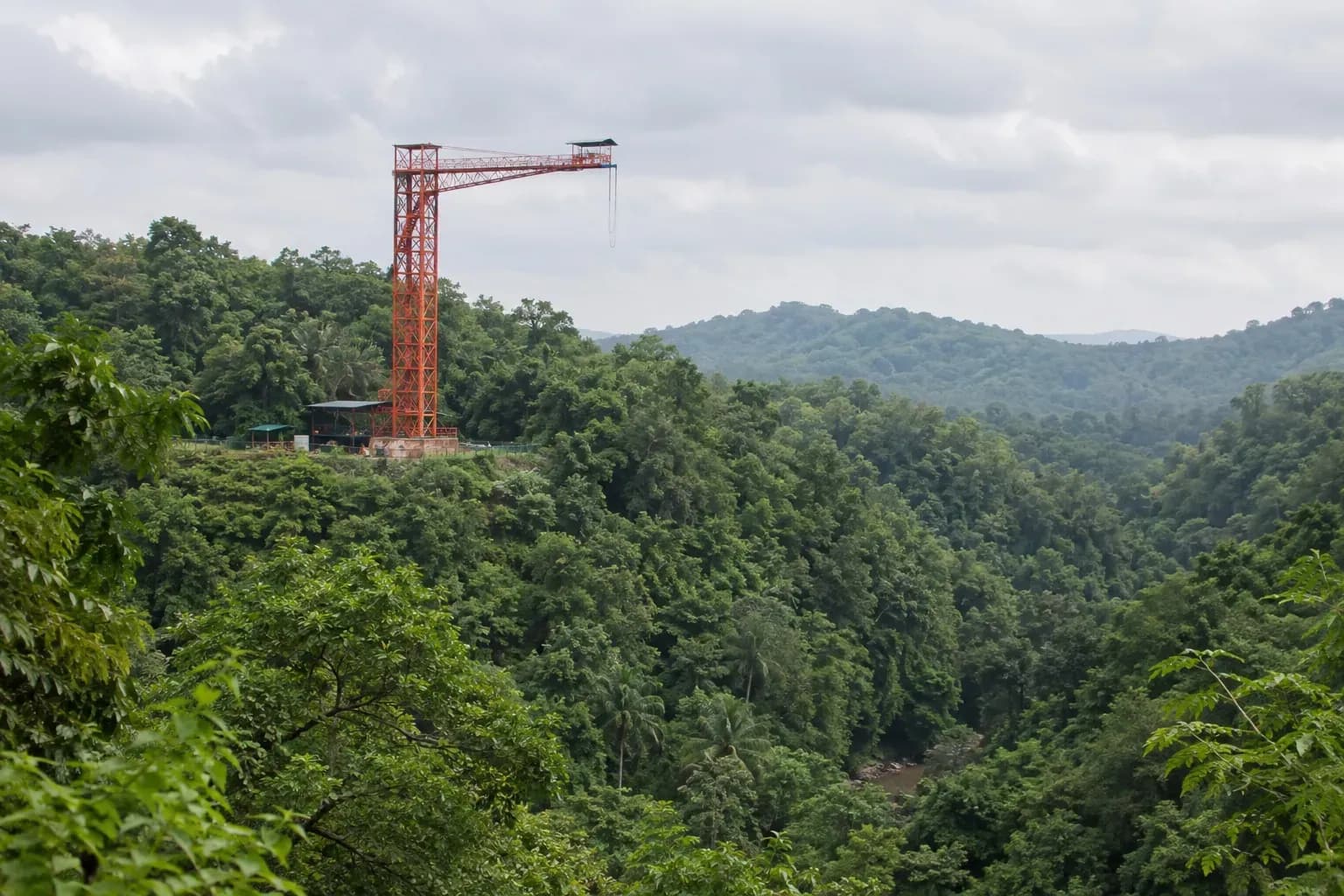 Red bungee platform above a forested Goa valley
