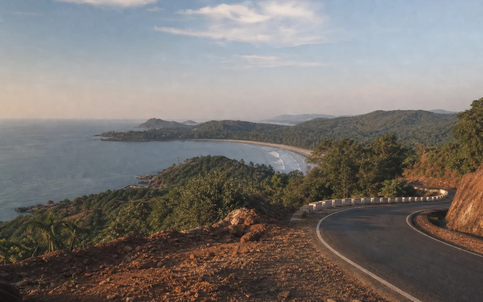 A coastal road curving toward Gokarna with forested headlands and the Arabian Sea