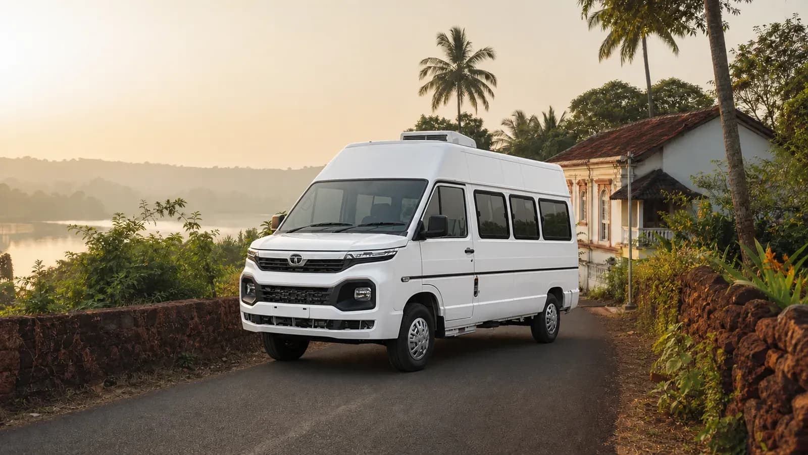 White Tata Winger Plus tourist van on a quiet laterite-lined road in Goa