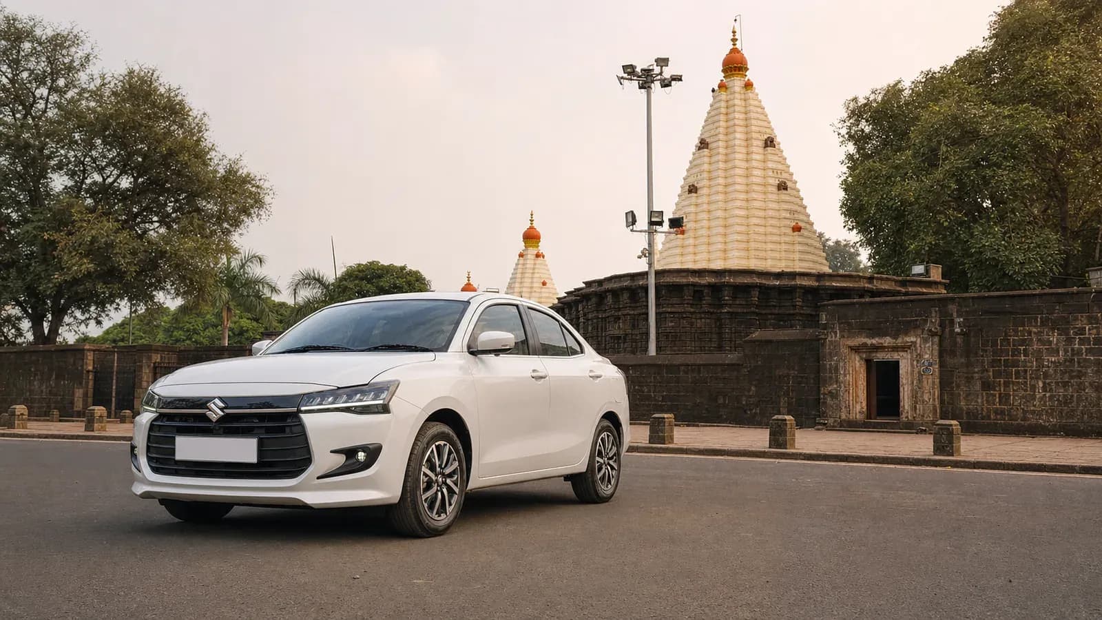 White Maruti Suzuki Dzire near the Mahalakshmi Temple precinct in Kolhapur