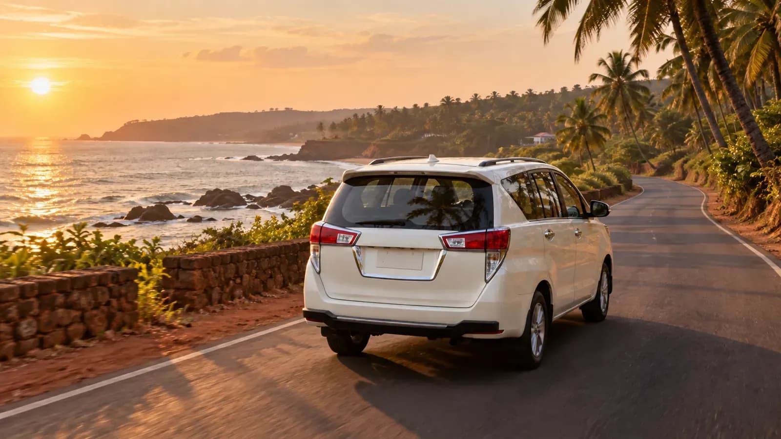 A white car on a Goa coast road at sunset